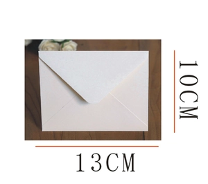 Detail view of 13x10cm ivory pearlescent paper envelope with V-flap on wooden background