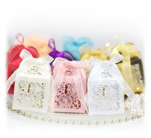 Laser cut hollow wedding candy boxes in multiple colors with silk ribbon bows for parties