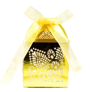 Close-up of laser-cut hollow pattern and silk ribbon on golden candy gift box