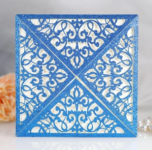 Macro view of blue glitter laser-cut wedding invitation with intricate lace patterns