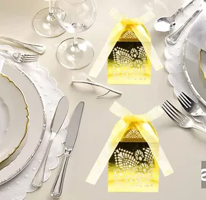 Detail of laser-cut ivory candy box with yellow ribbon for European wedding decoration