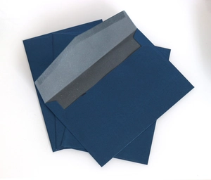 Detail view of deep blue pearlescent paper envelopes with elegant silver-gray inner lining