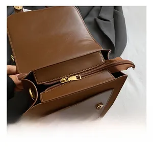 Detail view of small brown leather backpack with gold metal zipper and magnetic snap closure