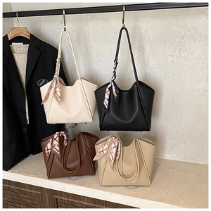 Dettaglio delle borse tote in ecopelle martellata con eleganti foulard di seta sui manici