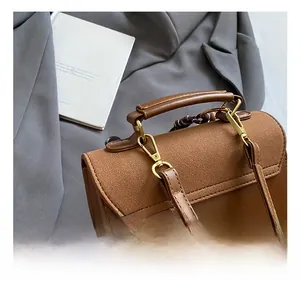 Close-up of brown vintage backpack featuring matte leather texture and gold metal hooks