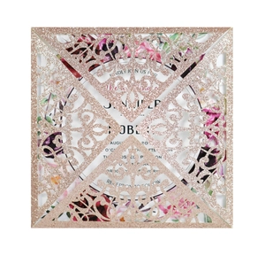 Macro detail of laser-cut rose gold glitter wedding invitation with floral insert card