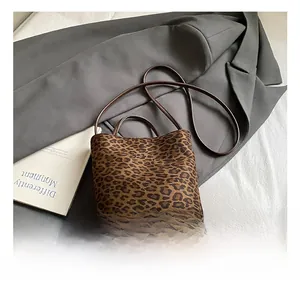 Detail of leopard print bucket bag with dual handles and slim shoulder strap