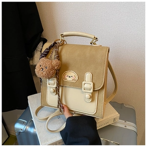 Detail of retro contrast stitching handbag with cute cartoon patch and plush bear charm