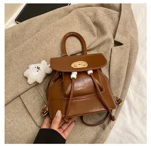 Detail of vintage brown PU leather backpack with cute dog patch and plush bear charm