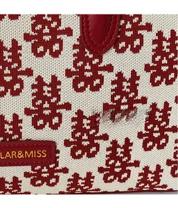 Macro view of red double happiness jacquard knit fabric and gold brand leather tag