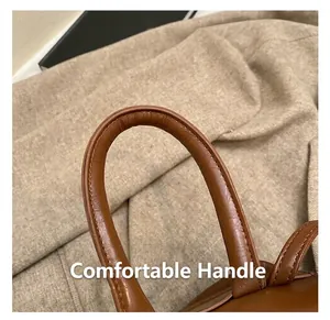 Close-up of the vintage leather backpack handle showing refined grain and stitching