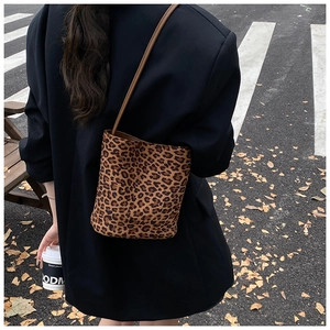 Street view of a woman wearing a leopard print bucket bag and black blazer in autumn
