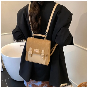 Rear view of a model wearing the mini khaki and beige patchwork backpack with dog patch