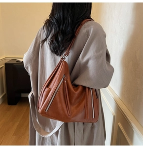 Brown soft leather shoulder bag with side zippers shown from a back perspective