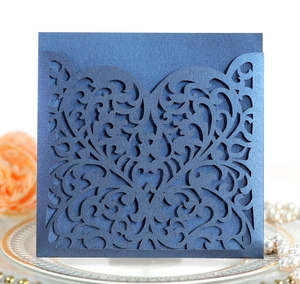 Close-up of laser-cut navy blue wedding invitation cover with elegant hollow floral pattern
