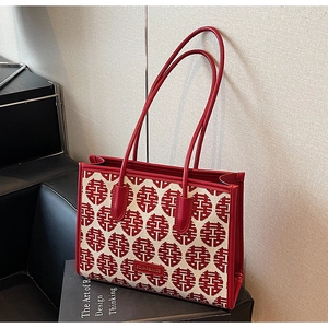 Detail of red wedding tote bag featuring festive double happiness jacquard and leather trim