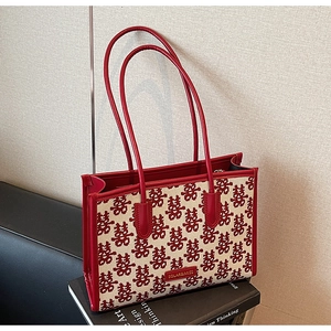 Macro view of Chinese wedding tote featuring red double happiness jacquard and leather trim