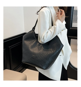 Detailed view of black woven texture on a versatile faux leather shoulder tote bag