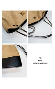 Detail of quilted suede shoulder bag featuring gold chain strap and metal hardware