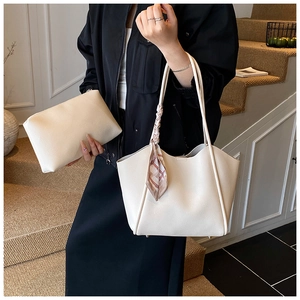 Dettaglio della borsa tote bianco crema in pelle martellata con foulard decorativo sul manico