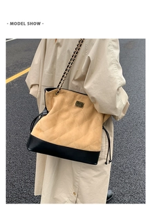 Quilted tote bag detail featuring contrast textures and metal chain shoulder straps