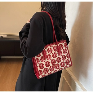 Detail of red festive wedding tote bag with traditional pattern and leather handles