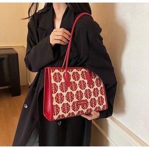 Detail of red festive tote bag with woven fabric and metal SOLAR & MISS logo