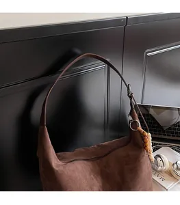 Detail of dark brown suede hobo bag with vintage wooden beads and silver metal rings