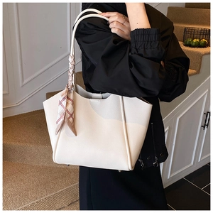 Dettaglio della borsa tote crema in pelle martellata con foulard decorativo chic