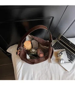 Spacious interior of brown faux suede hobo bag showing umbrella and water bottle