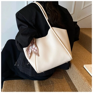 Dettaglio borsa shopper crema in finta pelle con foulard di seta decorativo sul manico
