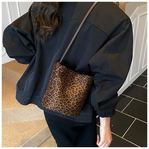 Sac seau à motif léopard porté à l'épaule avec bandoulière marron et aspect texturé