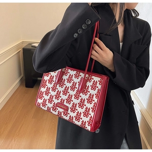 Detail of red festive wedding tote bag with Xi characters and leather trim