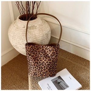 Détail d'un sac seau à imprimé léopard avec bandoulière en cuir et design vintage