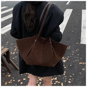 Grand sac cabas marron foncé en daim mat porté à l'épaule du mannequin pour le volume