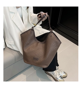 Detailed close-up of brown woven leather bucket tote bag with BEKEDOO logo tag