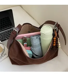 Vue détaillée de l'intérieur du sac en daim marron montrant sa grande capacité de rangement