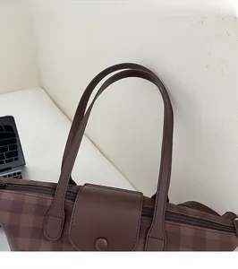 Detail view of the brown checkered tote bag with long comfortable shoulder straps