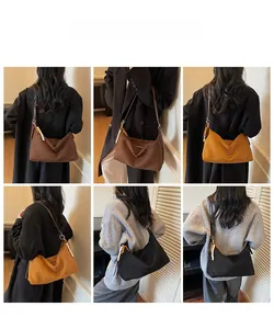 Vue détaillée du sac hobo en daim avec pompon perlé en noir et marron élégant
