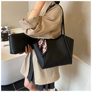 Dettagli della borsa tote in pelle nera con foulard di seta e piedini in metallo