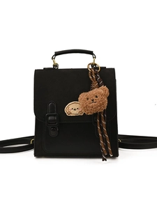 Mini black backpack with matte fabric and cute bear pendant on a white background