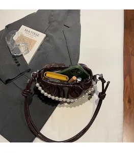 Détail de l'intérieur du sac plissé marron foncé montrant la capacité de rangement