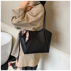 Vista laterale della borsa tote nera a grana con foulard di seta decorativo