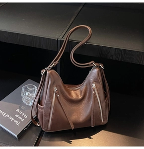 Detail view of dark brown PU leather tote bag with functional zippers and wide strap