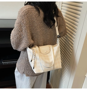 Detailed view of white checkered tote bag with flap closure and adjustable strap