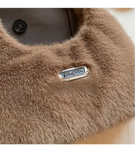 Gros plan sur la texture en fausse fourrure marron et la plaque en métal sur le sac