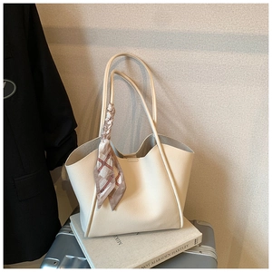 Dettaglio della borsa tote bianco sporco trama litchi con foulard di seta sulla tracolla
