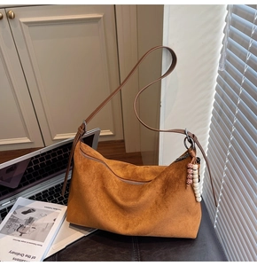 Détails du sac hobo en daim caramel avec bandoulière réglable et breloque perlée