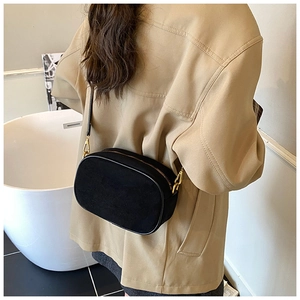 Detail of black frosted crossbody bag with gold hardware and minimalist square design