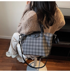 Detailed side view of large plaid tote bag showing texture and adjustable strap